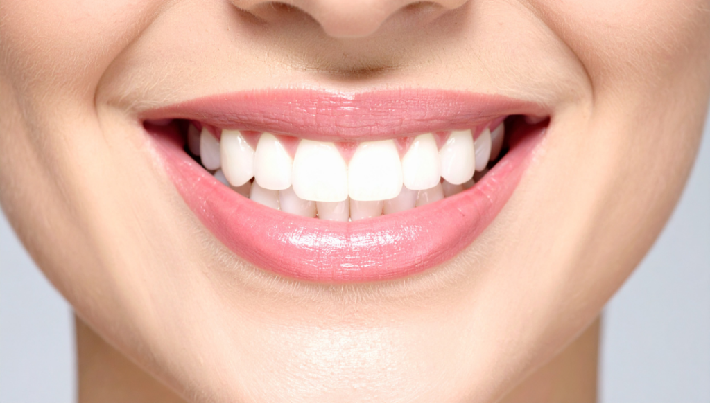 A close-up of a healthy, bright smile with perfectly contoured pink gums, showcasing the ideal results of successful pocket reduction surgery and periodontal maintenance.